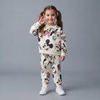 Niña sonriente vistiendo conjunto EmpiBy de dos piezas blanco con estampado de Minnie, Mickey y Pluto