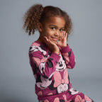 Niña sonriente vistiendo conjunto EmpiBy de dos piezas fucsia con estampado de Minnie Mouse y cuello redondo
