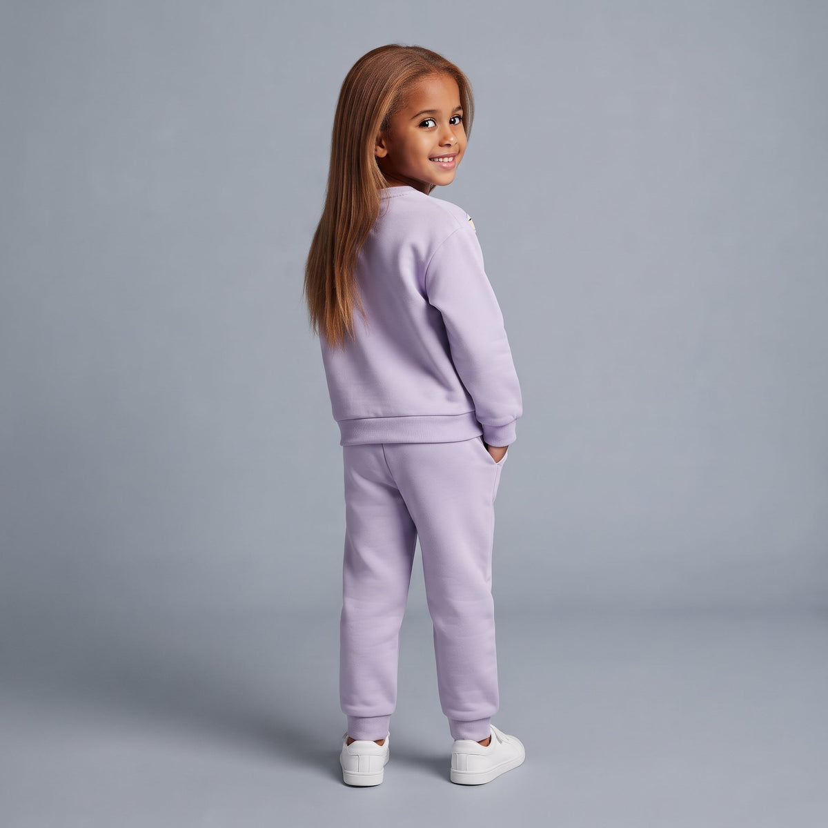 Niña sonriente vistiendo conjunto EmpiBy de sudadera y jogger lila pastel con diseño de Minnie Mouse
