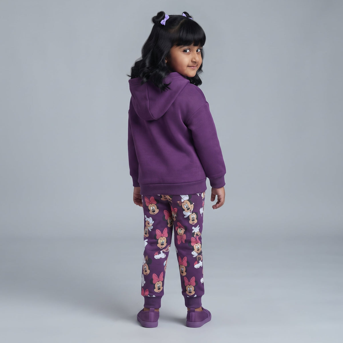 Niña vistiendo conjunto EmpiBy de sudadera morada con capucha y pantalón jogger estampado de Minnie Mouse
