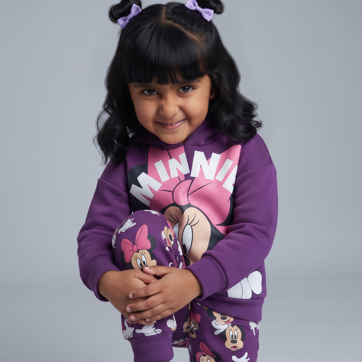 Niña vistiendo conjunto EmpiBy de sudadera morada con capucha y pantalón estampado de Minnie Mouse