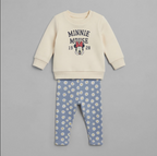 Conjunto EmpiBy de dos piezas para bebé niña con sudadera beige de Minnie Mouse y pantalón azul con estampado floral.