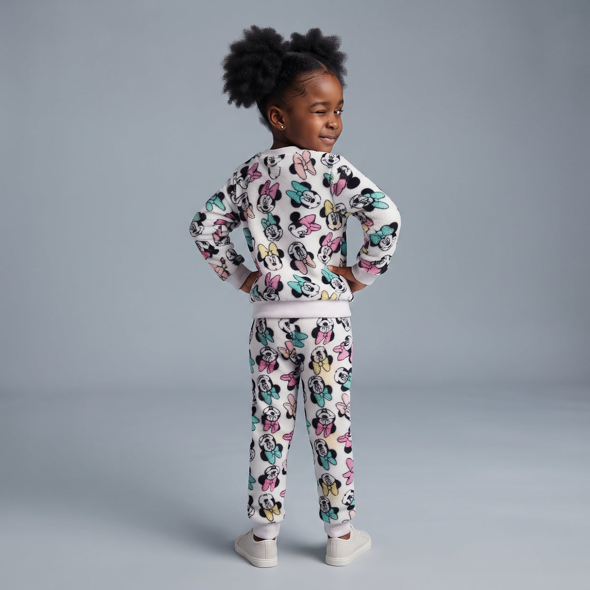 Niña posando de espaldas con conjunto EmpiBy de dos piezas blanco con estampado de Minnie Mouse en tela tipo peluche