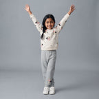 Niña sonriente con conjunto EmpiBy de sudadera blanca estampada de Minnie Mouse y pantalón jogger gris cómodo.