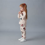 Niña con conjunto EmpiBy de dos piezas de Minnie Mouse en blanco y rojo, sudadera y jogger con estampado clásico.