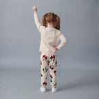 Niña de espaldas vistiendo conjunto EmpiBy de dos piezas con estampado de Minnie Mouse en tonos blanco y rojo