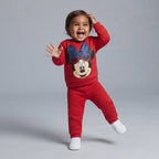 Bebé feliz vistiendo conjunto EmpiBy de dos piezas rojo con estampado de Minnie Mouse y lazo brillante