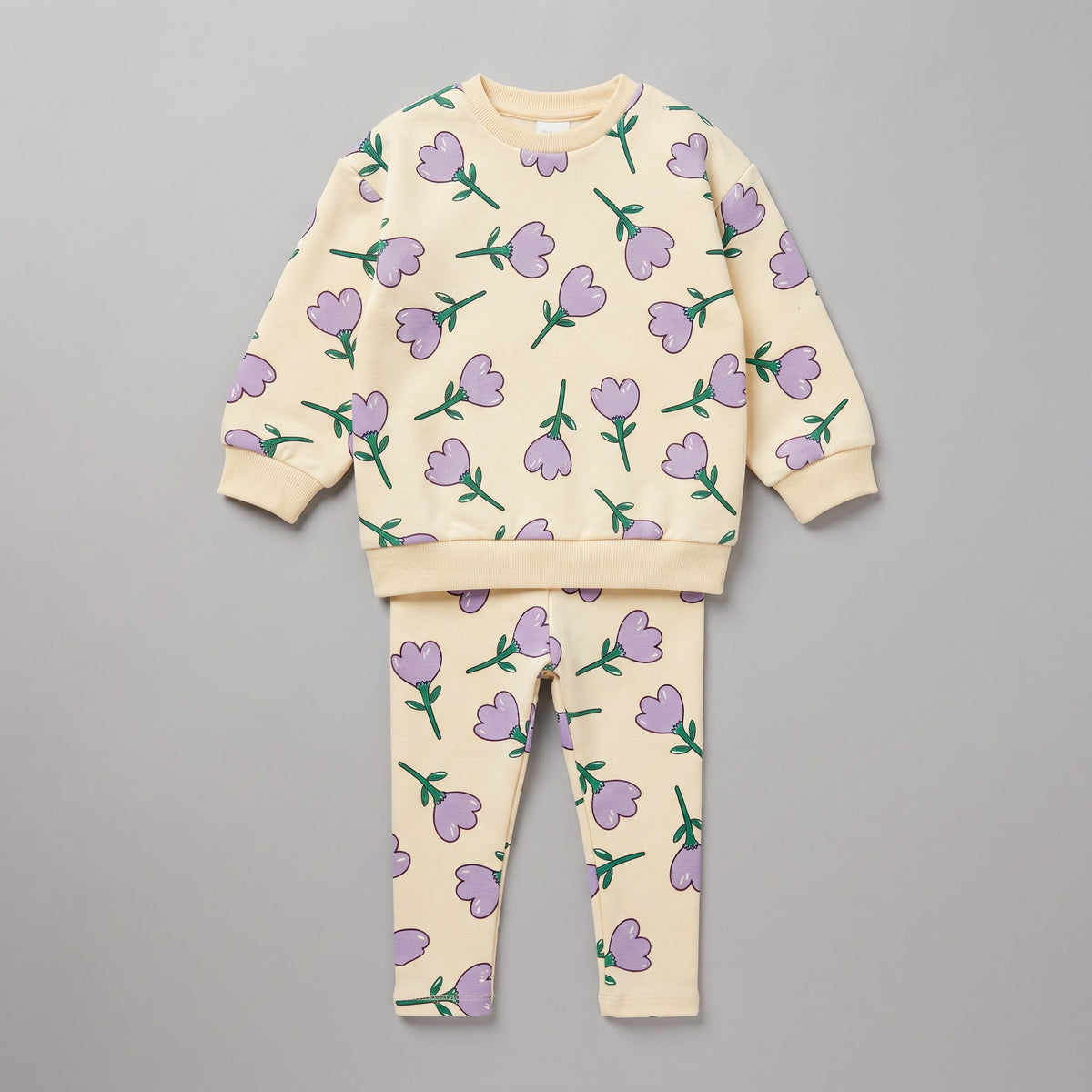 Conjunto EmpiBy de dos piezas para niña con estampado de tulipanes morados sobre fondo crema, sudadera y legging.