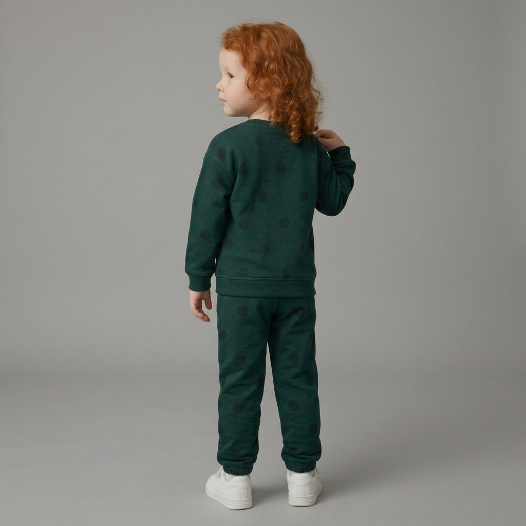 Niña de espaldas vistiendo conjunto EmpiBy de sudadera y jogger verde oscuro con estampado de lunares