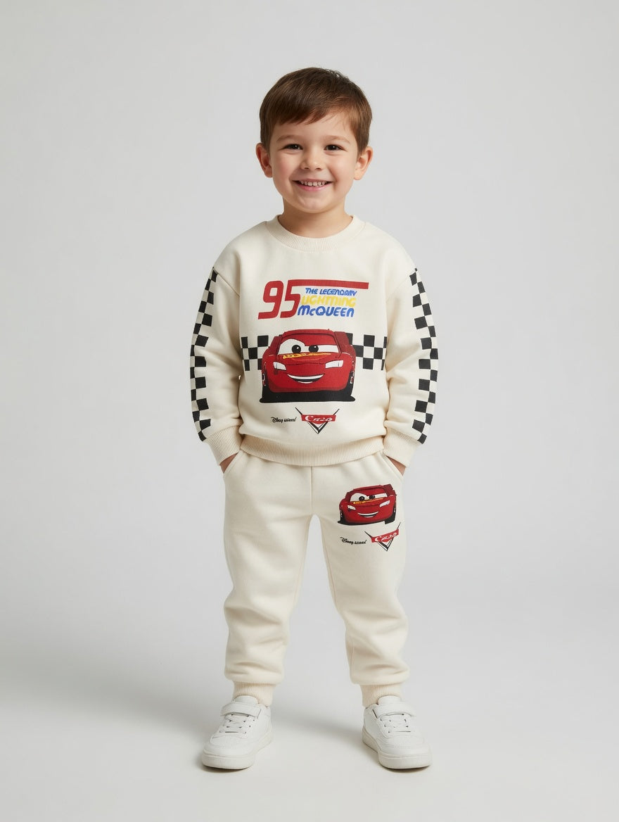 Niño vistiendo conjunto EmpiBy de sudadera y pantalón color crema con estampado de Rayo McQueen y detalles de carreras