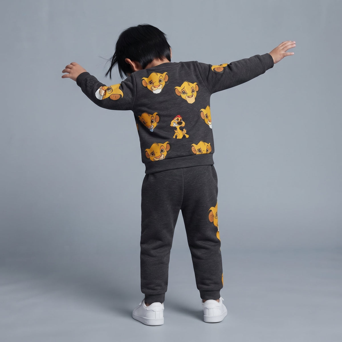 Niño de espaldas vistiendo conjunto EmpiBy gris oscuro con estampado de Simba y Timón de El Rey León