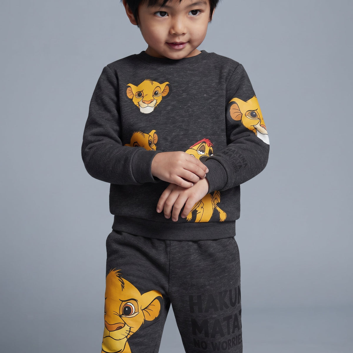 Conjunto EmpiBy de dos piezas gris oscuro con estampado de Simba y Timón para niño, sudadera y jogger cómodos.
