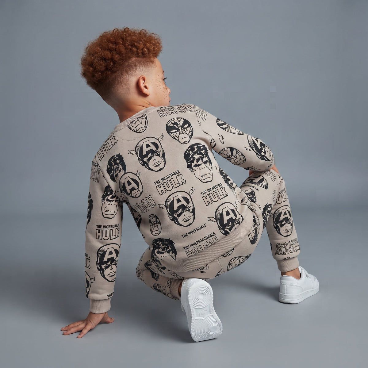 Niño vistiendo conjunto EmpiBy de dos piezas beige con estampado de superhéroes Marvel, vista trasera