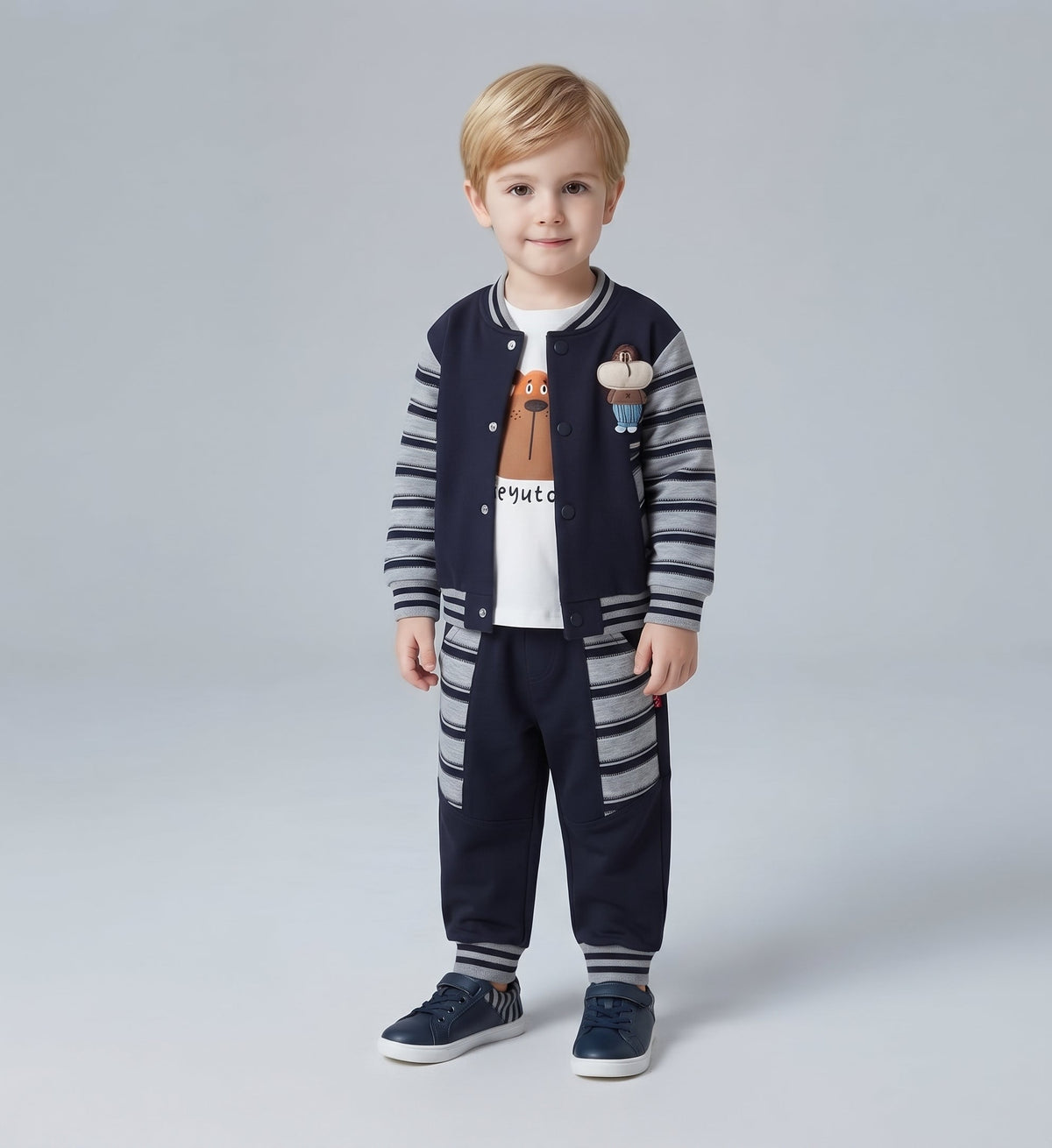 Niño pequeño vistiendo conjunto EmpiBy de 3 piezas: chaqueta bomber azul, camiseta de oso y pantalón a juego