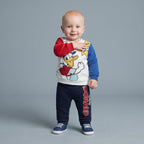 Bebé niño vistiendo conjunto EmpiBy de dos piezas con sudadera del Pato Donald y pantalón jogger azul marino