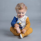 Bebé sonriente con conjunto EmpiBy de dos piezas del Pato Donald en tonos mostaza y azul con estampado de cómics