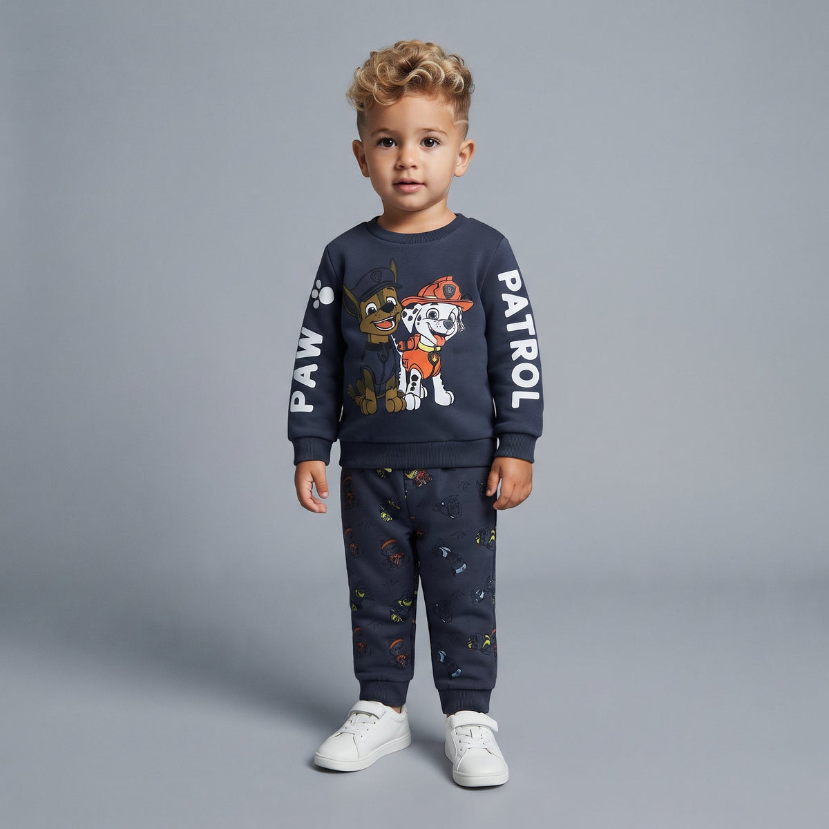 Niño vistiendo conjunto EmpiBy de Paw Patrol con sudadera gris oscuro de Chase y Marshall y pantalón jogger estampado