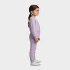 Niña de perfil vistiendo conjunto EmpiBy de sudadera y pantalón polar en color lila suave con diseño estampado