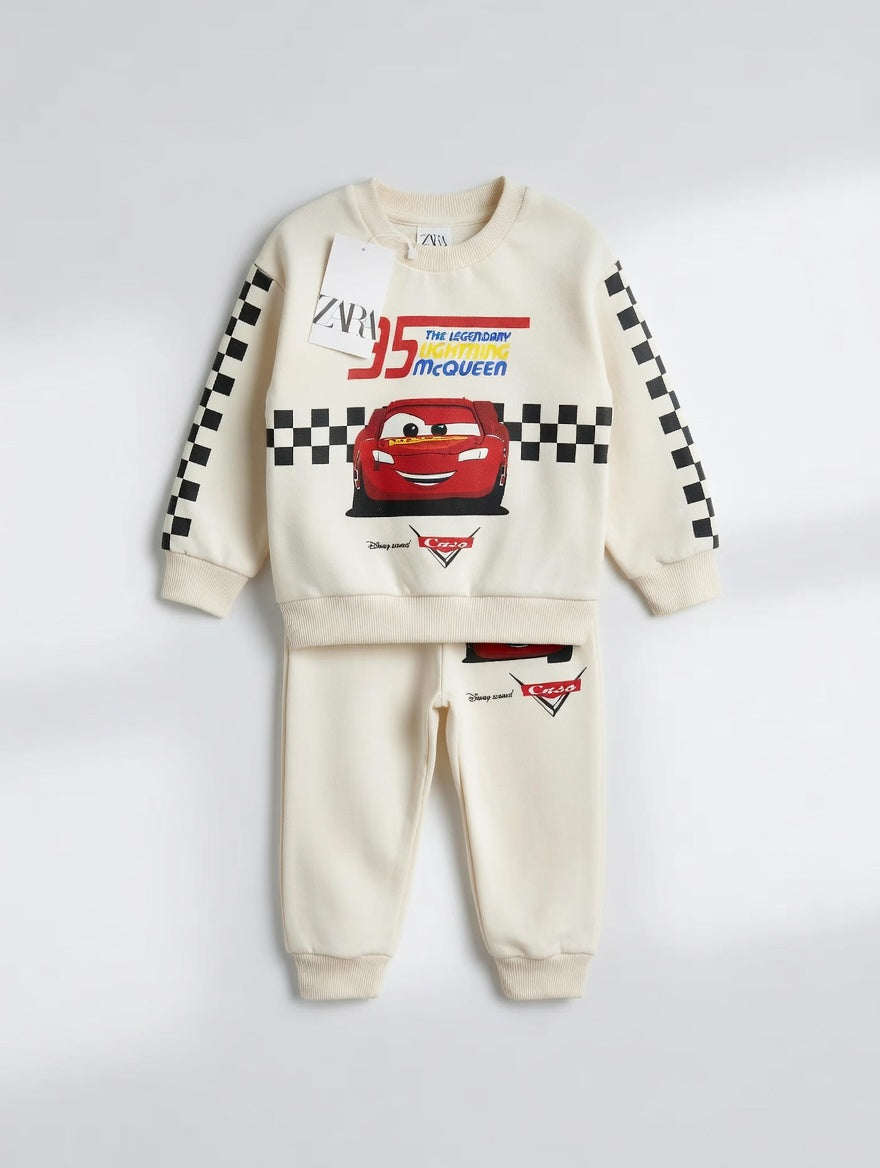 Conjunto EmpiBy de sudadera y pantalón color crema con estampado de Rayo McQueen y detalles de cuadros de carreras.