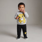 Bebé niño vistiendo conjunto EmpiBy de dos piezas con sudadera gris de Simba y pantalón jogger negro cómodo