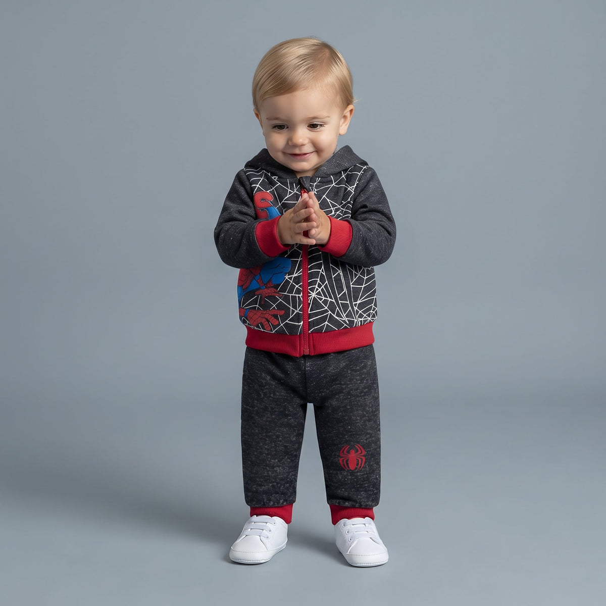 Bebé con conjunto EmpiBy de dos piezas de Spider-Man, sudadera gris con cremallera y pantalón jogger a juego.