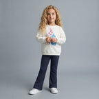 Niña vistiendo conjunto EmpiBy de sudadera color hueso con estampado de Stitch y Angel y pantalón azul marino