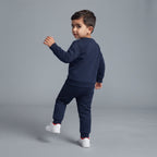 Niño vistiendo conjunto EmpiBy de sudadera y pantalón jogger azul marino de felpa suave, vista trasera.