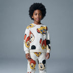 Niño vistiendo conjunto EmpiBy de sudadera y pantalón con estampado colorido de personajes clásicos de Disney