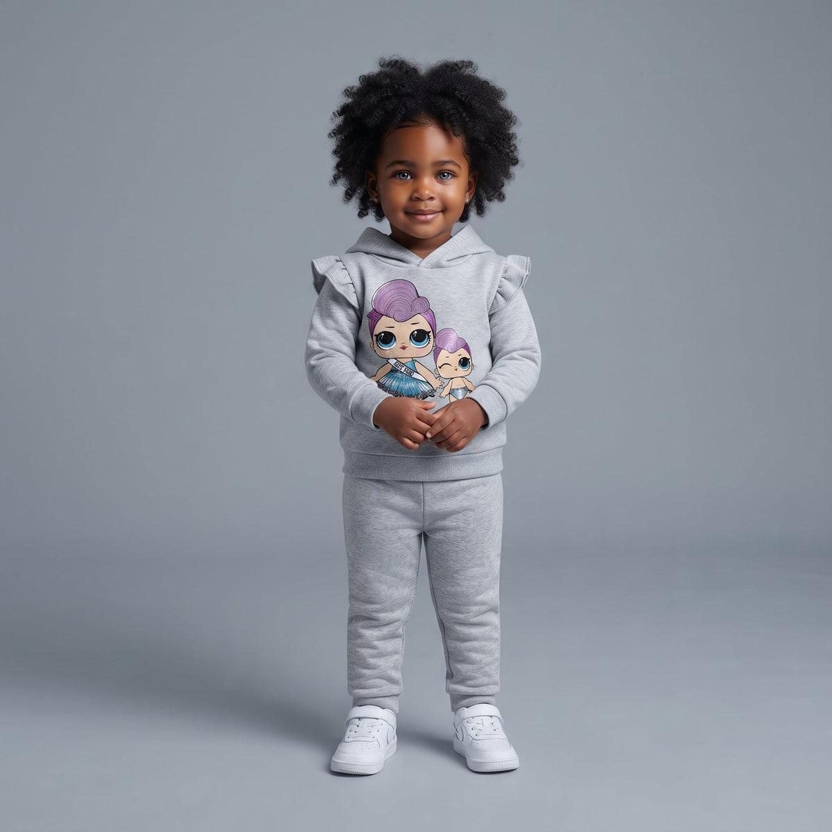 Niña pequeña vistiendo conjunto gris EmpiBy de dos piezas con sudadera de volantes y estampado de muñecas Pop