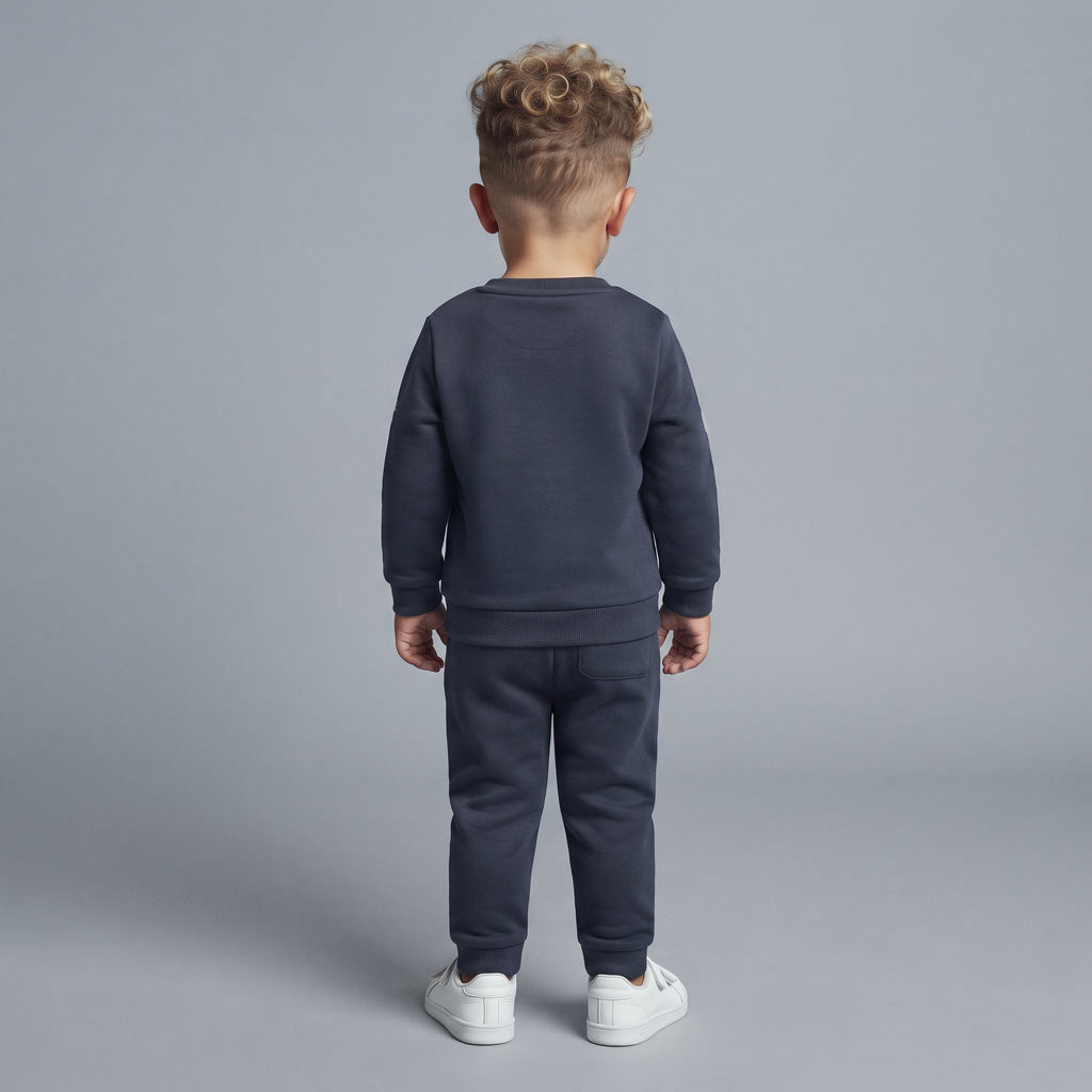 Niño de espaldas vistiendo conjunto EmpiBy de sudadera y pantalón jogger gris oscuro de Paw Patrol con zapatillas