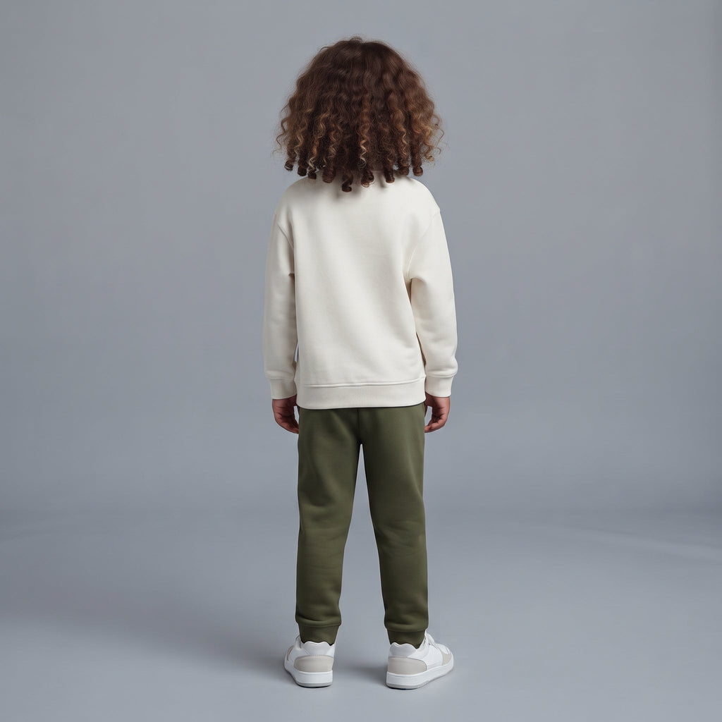 Vista trasera de niño con conjunto EmpiBy de sudadera marfil y pantalón jogger verde oliva sobre fondo gris