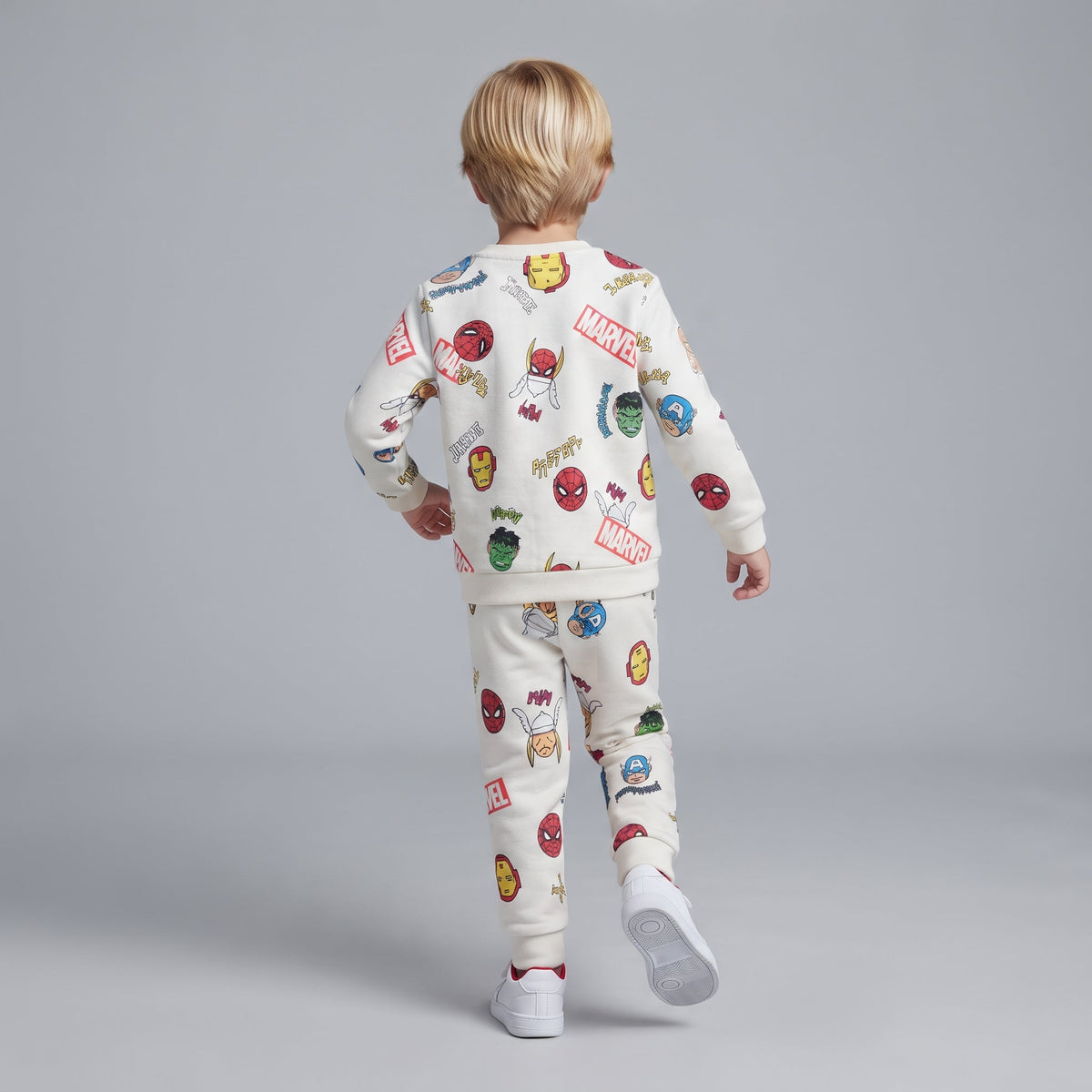 Niño de espaldas vistiendo conjunto EmpiBy de sudadera y jogger marfil con estampado de superhéroes Marvel