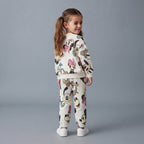 Niña luciendo conjunto EmpiBy de dos piezas blanco con estampado de Minnie y amigos, sudadera y jogger cómodos.