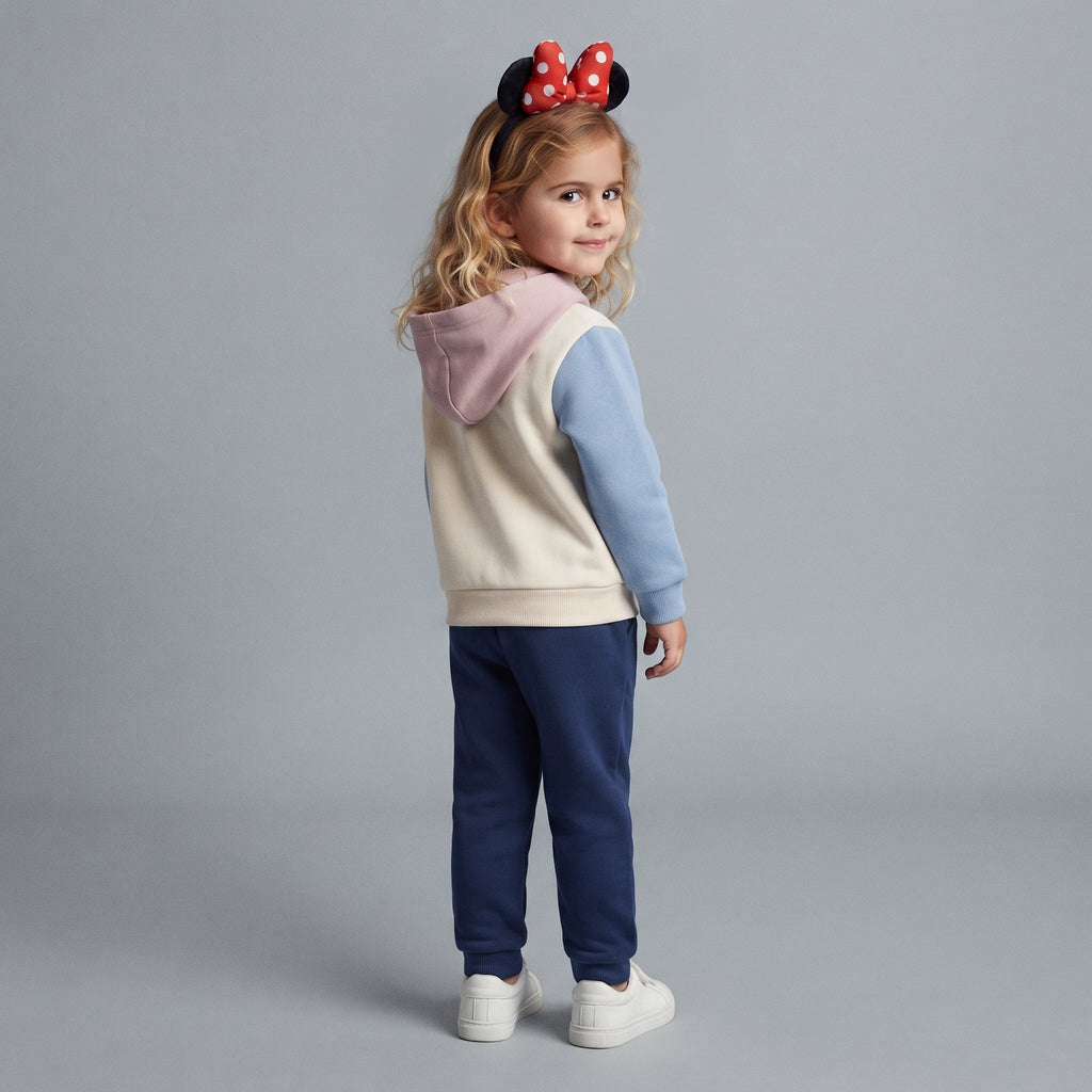 Niña con conjunto EmpiBy de sudadera con capucha rosa y crema y pantalón jogger azul marino de Minnie Mouse