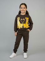 Niña sonriente vistiendo conjunto EmpiBy de sudadera y jogger marrón chocolate con estampado de Simba y Nala de Disney