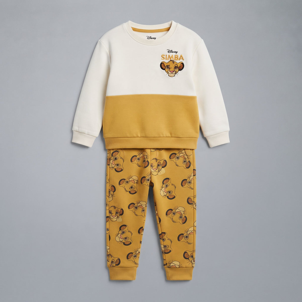 Conjunto EmpiBy de dos piezas de El Rey León con sudadera color-block crema y mostaza y jogger estampado de Simba