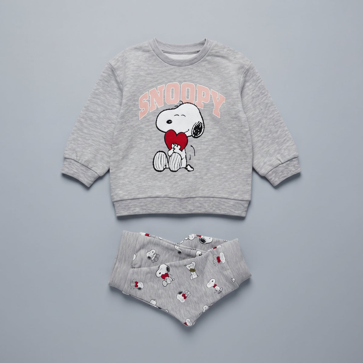 Conjunto EmpiBy de dos piezas para bebé niña, sudadera gris con Snoopy y corazón rojo, y legging estampado a juego.