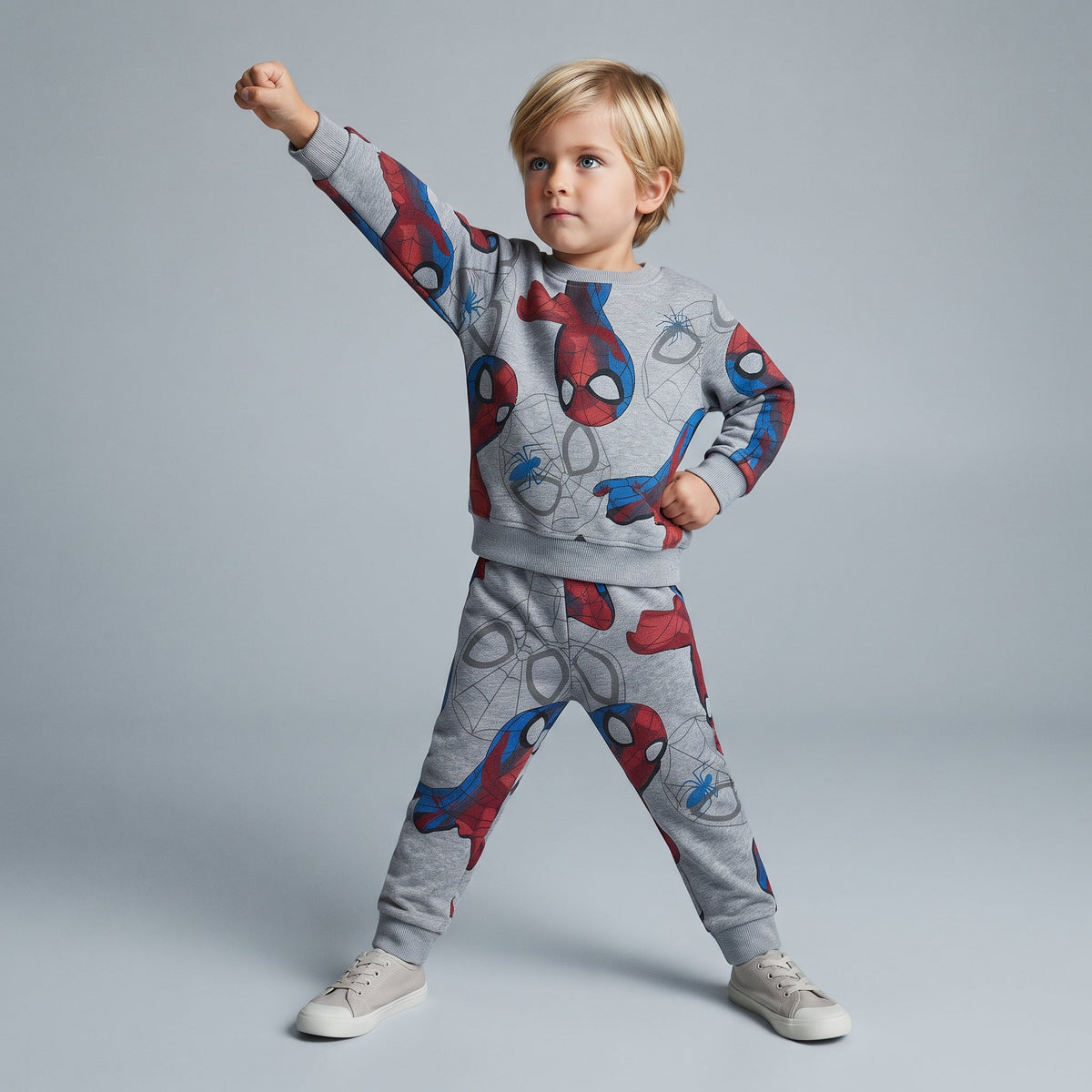 Niño posando con conjunto de sudadera y jogger gris EmpiBy con estampado de Spider-Man y detalles de telarañas