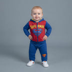 Bebé sonriente con conjunto EmpiBy de Superman, sudadera roja y azul con cremallera y pantalón jogger a juego.