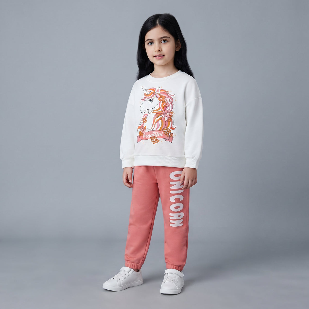 Niña vistiendo conjunto EmpiBy de sudadera cruda con unicornio y pantalón jogger coral con texto lateral