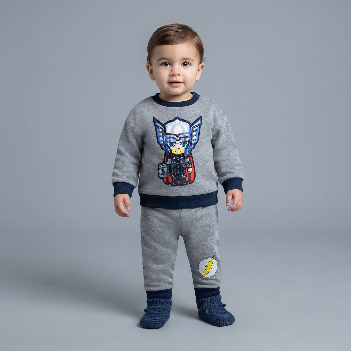 Bebé con conjunto EmpiBy de dos piezas gris de Thor, sudadera con parche de superhéroe y pantalón jogger con rayo.