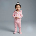 Niña pequeña vistiendo conjunto EmpiBy de tres piezas: chaqueta rosa con lunares, body blanco y pantalón a rayas