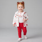 Niña pequeña vistiendo conjunto EmpiBy de tres piezas con chaqueta estampada, body blanco y leggings rojos a puntos.