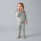 Niña pequeña vistiendo conjunto EmpiBy de tres piezas en verde salvia con sudadera floral, body y pantalón cómodo.