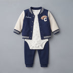 Conjunto EmpiBy de 3 piezas para bebé niño con chaqueta varsity azul y crema, body de fútbol y pantalón deportivo.