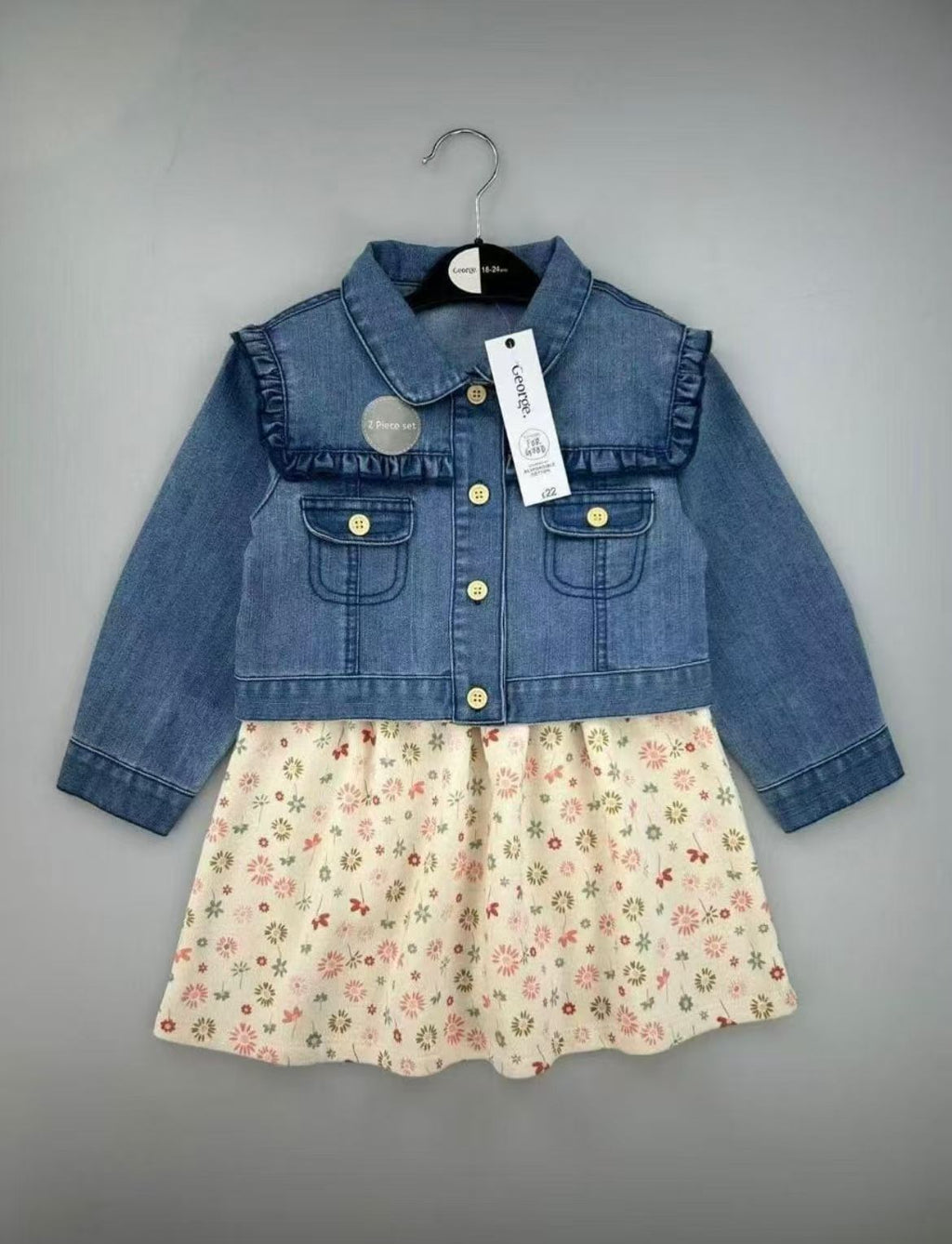 Conjunto EmpiBy para bebé niña con vestido de flores y chaqueta de mezclilla azul con volantes en los hombros.