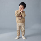 Niño vistiendo conjunto EmpiBy de dos piezas con sudadera beige de Winnie the Pooh y pantalón jogger a rayas