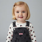Niña pequeña con conjunto EmpiBy de overol de mezclilla oscuro y camiseta blanca con estampado de Minnie Mouse