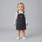 Niña pequeña vistiendo conjunto EmpiBy de vestido peto de mezclilla negra con Minnie y camiseta blanca estampada