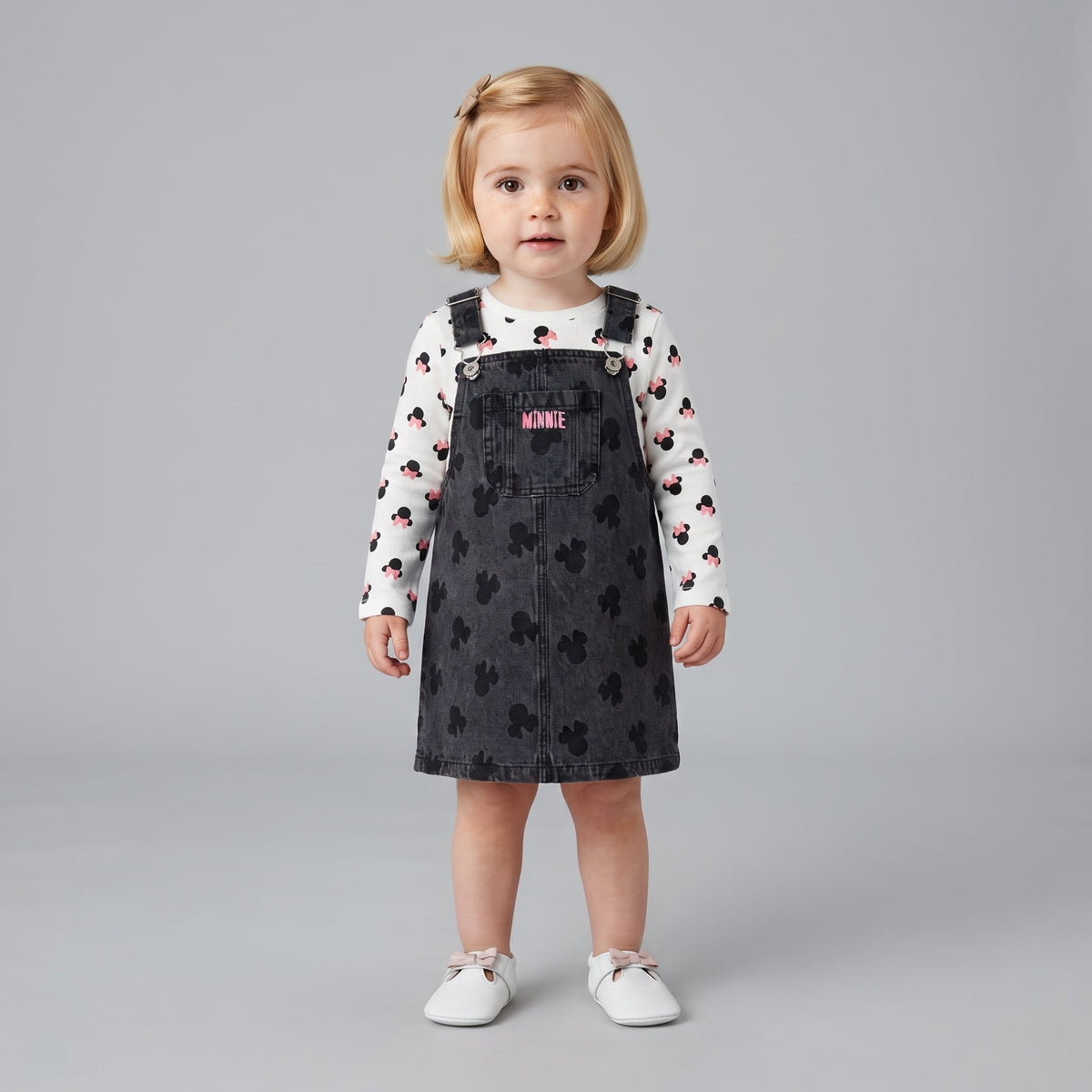Niña pequeña vistiendo conjunto EmpiBy de vestido peto de mezclilla negra con Minnie y camiseta blanca estampada